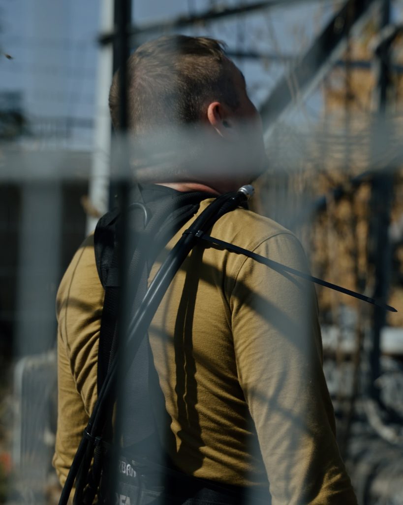 Зв'язківець у спеціальному спорядженні оглядає конструкцію для встановлення обладнання зв'язку.